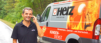 Herz szervizes telefonál a Herz furgon mellett