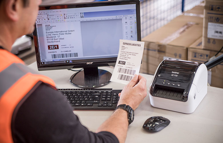 Brother QL nyomtató a monitor mellett, raktárban nyomtatott szállítási címkével