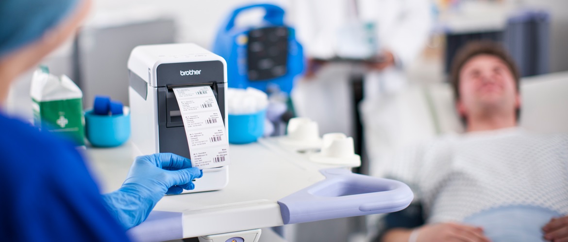 Brother label printer outputting, with nurse in blue uniform